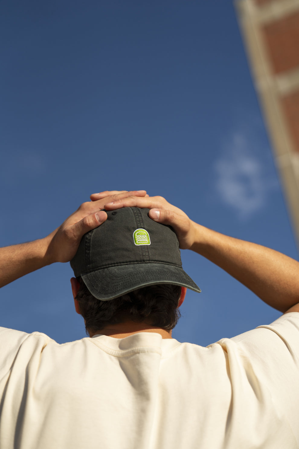 Person outside wearing Shake Shack dad hat backwards