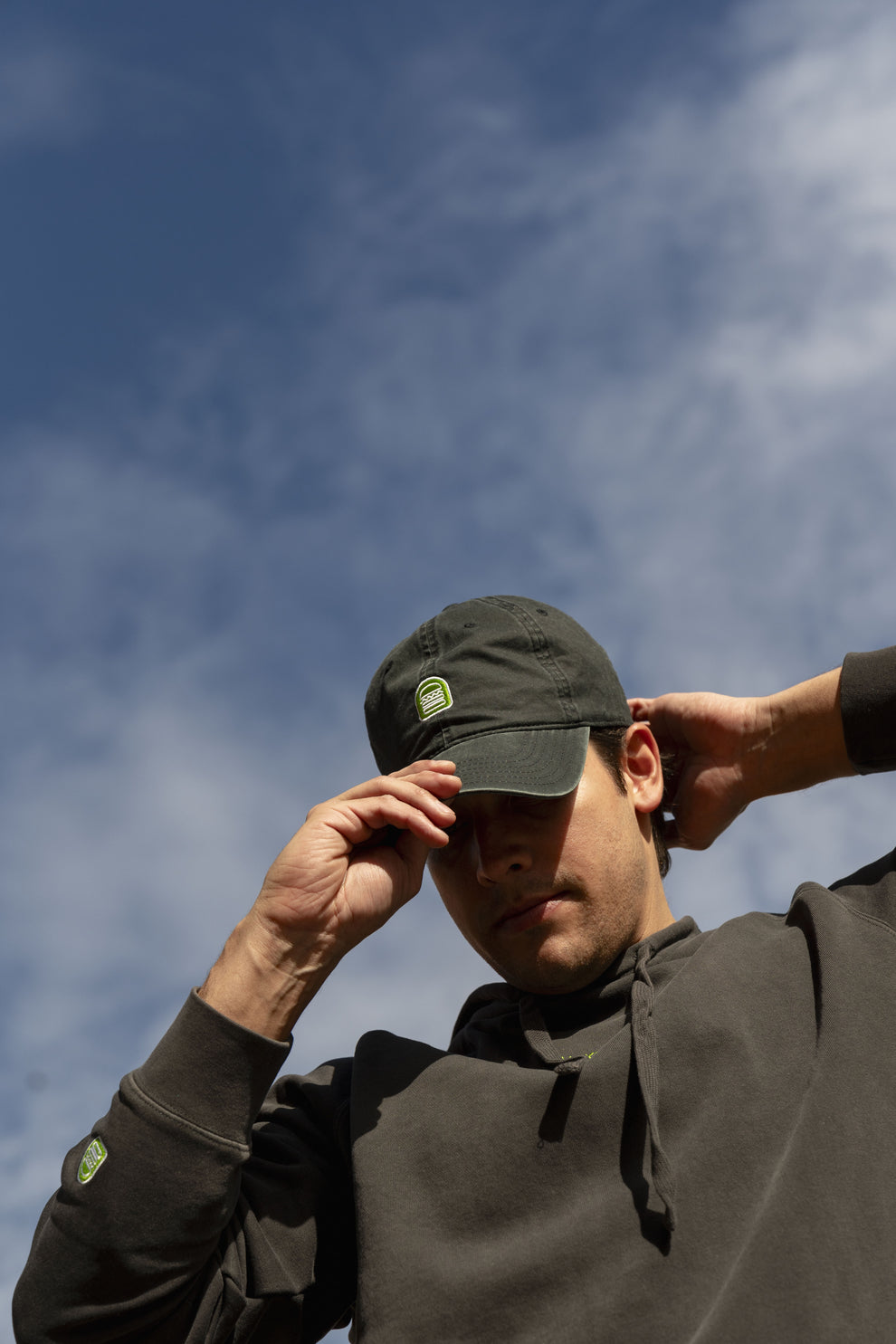 Person outside wearing Shake Shack dad hat and black hoodie