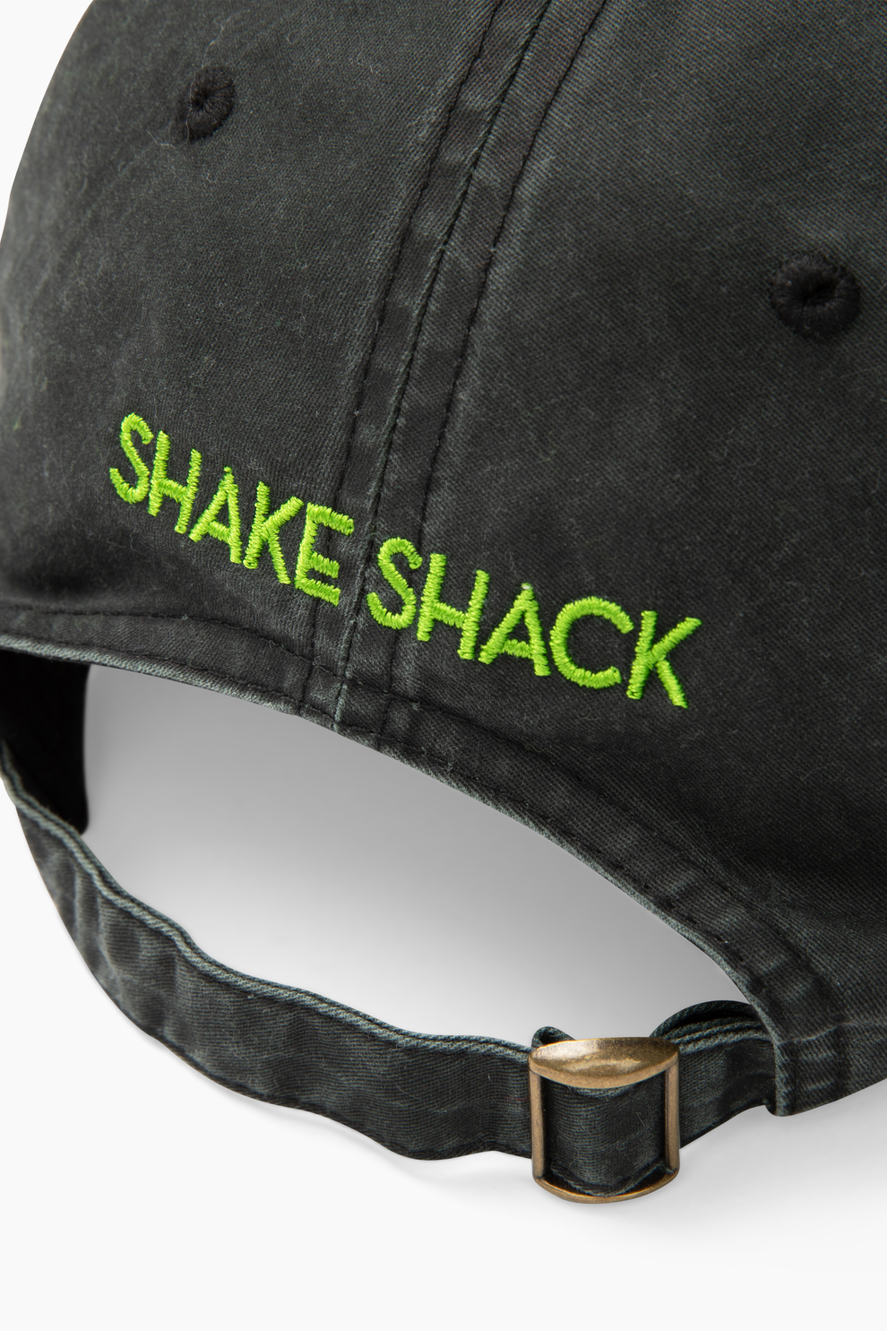 Closeup of the grey dad hat with the words "Shake Shack" embroidered on the back