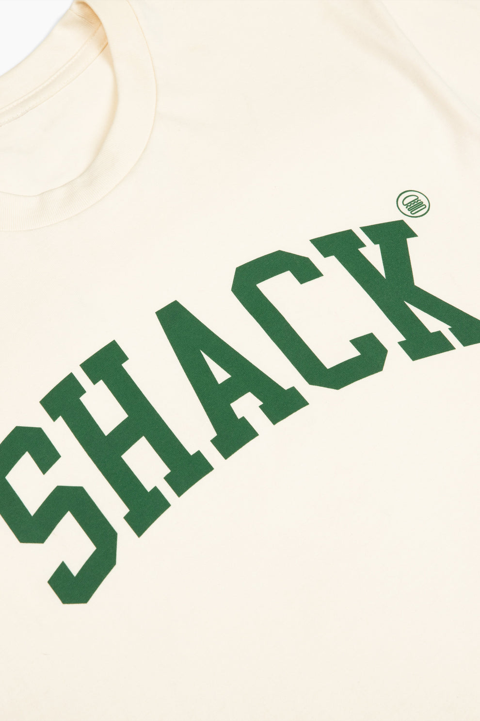Closeup of the cream-colored sweatshirt with the word "Shack" displayed across the chest