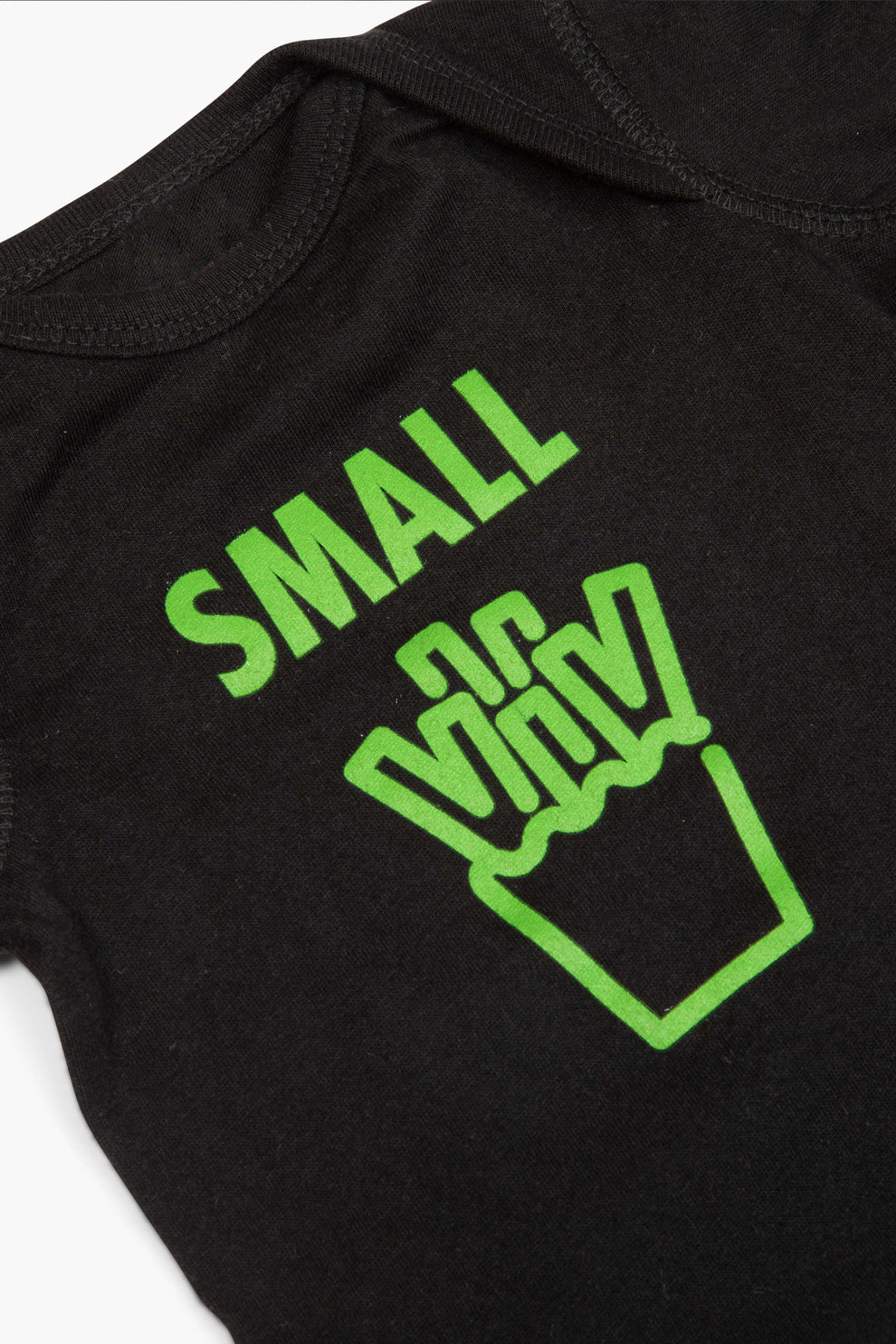 Closeup image of a black onesie with the word "Small" and a graphic of french fries below it