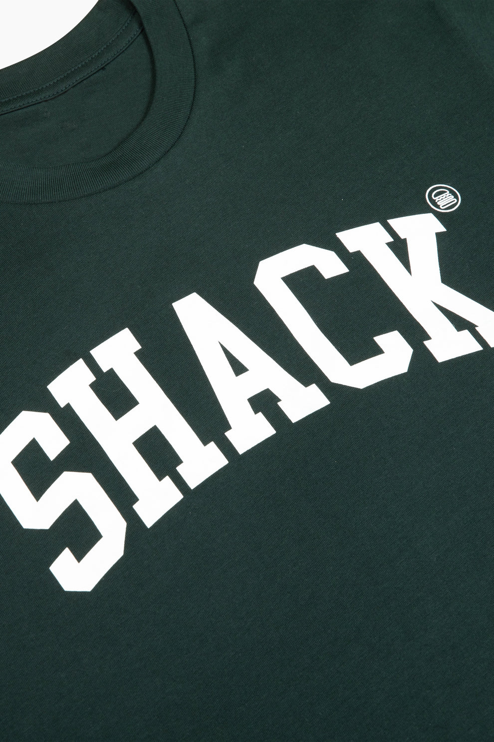 Closeup of the forest green t-shirt with the word "Shack" displayed across the chest